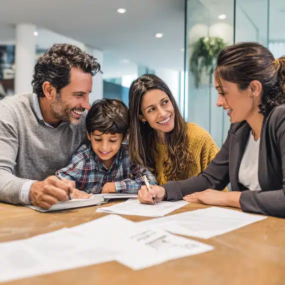 Hispanic family of four and an advisor reviewing CalHFA housing documents in an office.