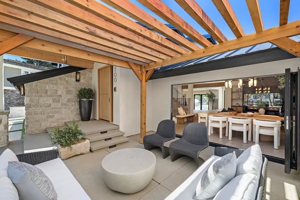 Covered outdoor patio and entry at 1700 Port Ashley Pl in Newport Beach with wood pergola and folding glass doors