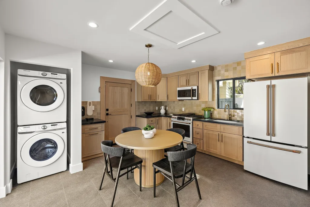 Laundry room at 1700 Port Ashley Pl Newport Beach with washer, dryer, utility sink and built-in cabinets