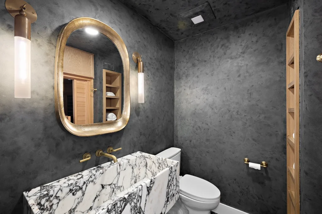 Luxury powder room at 1700 Port Ashley Pl Newport Beach with dark textured walls and marble sink