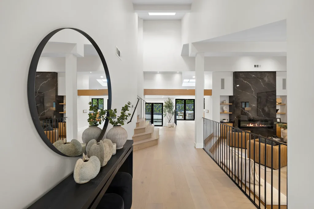Modern interior hallway at 1700 Port Ashley Pl Newport Beach with light wood floors and black marble fireplace