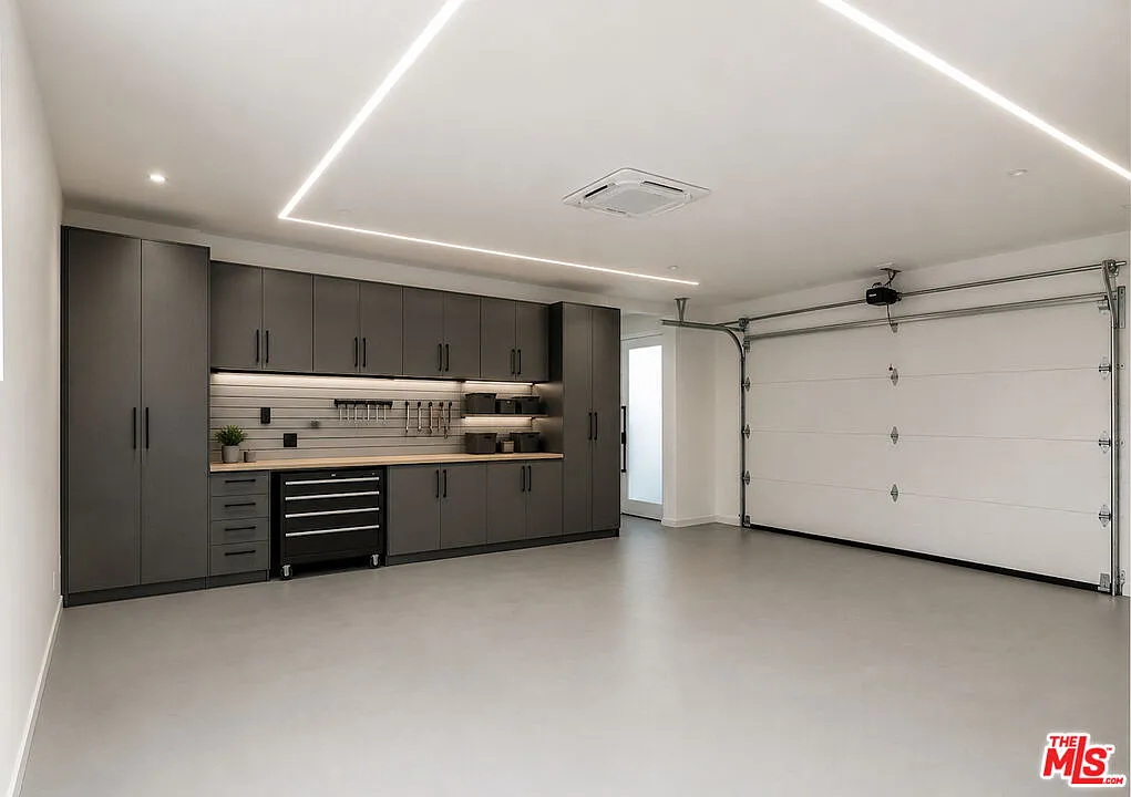 Modern garage interior at 2202 California Ave in Santa Monica featuring custom storage cabinets, polished flooring, integrated lighting and contemporary design