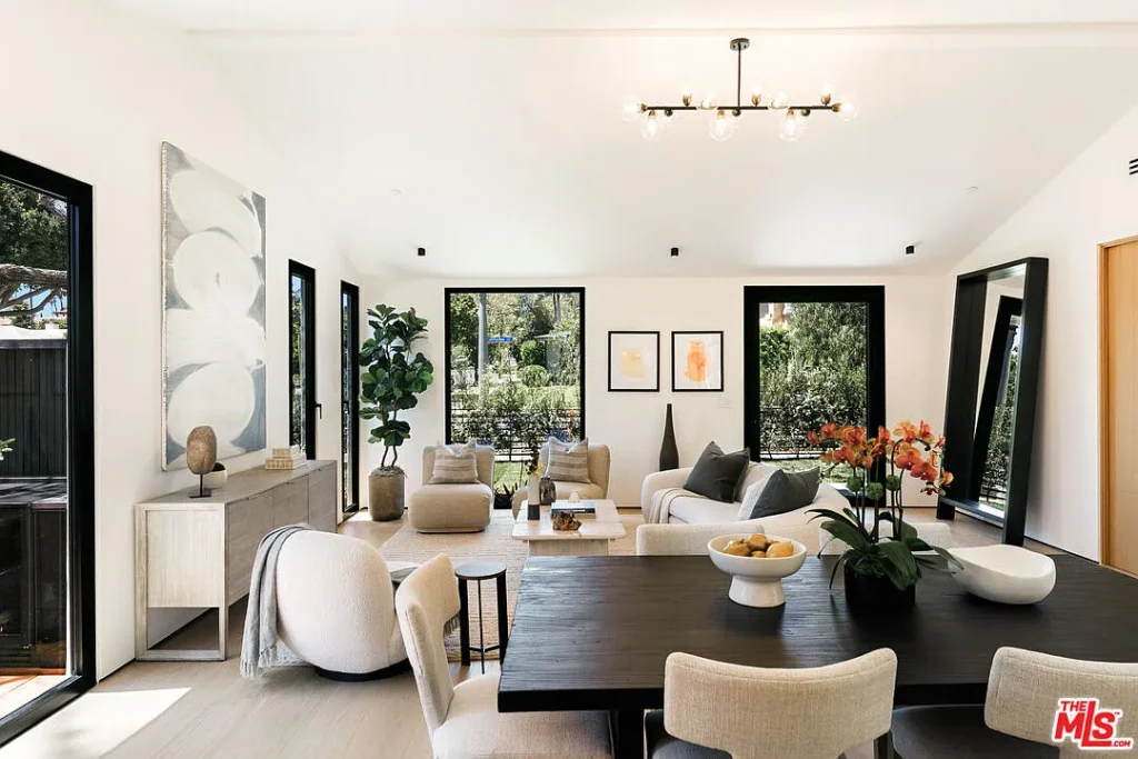 Modern open-plan living and dining room at 2202 California Ave in Santa Monica with large black-framed windows, neutral furnishings and contemporary interior design