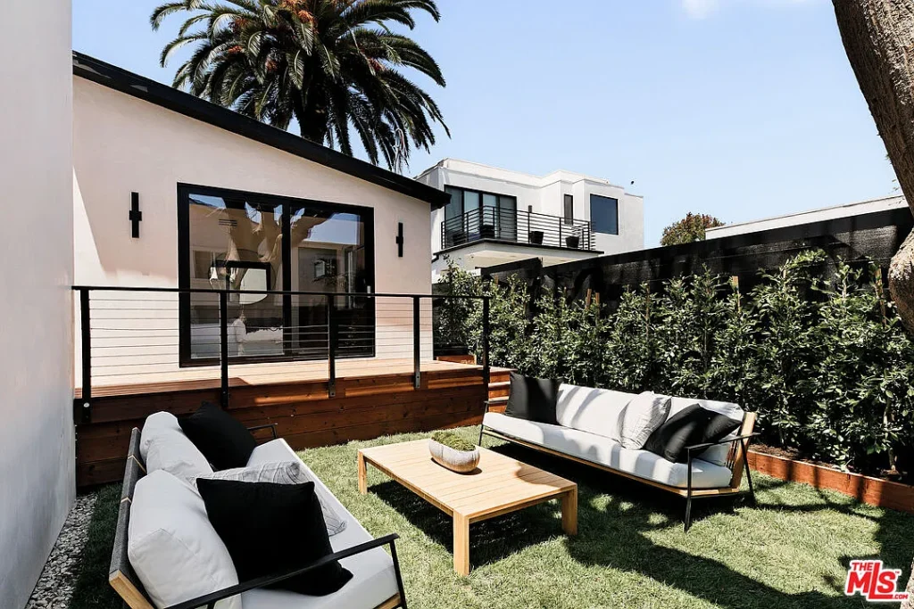 Modern outdoor patio at 2202 California Ave in Santa Monica featuring contemporary lounge furniture, landscaped garden, wood decking and stylish exterior design